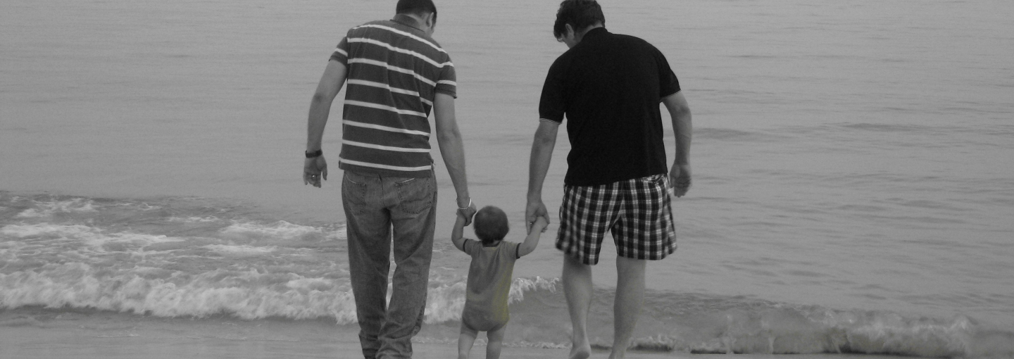 Gay Family Building Image - two parents with baby on beach