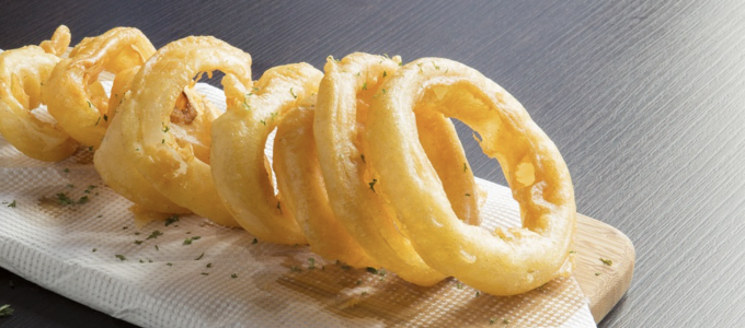 Image - a row of onion rings on a wood serving board