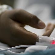 Pandemic Health-Care Inequities: How They Put All Americans at Risk Image - photos of hospital patient's hand