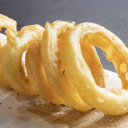 Image - a row of onion rings on a wood serving board