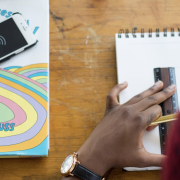 Bridging the Digital Divide Image - student working with pencil, ruler and paper next to book and smarphone