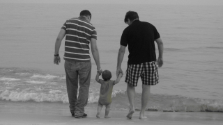 Image - two parents with baby on beach