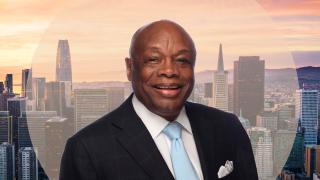 Image - photo of speaker and background of San Francisco skyline